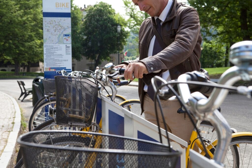 A man rents a bicycle from a bike-sharing scheme
